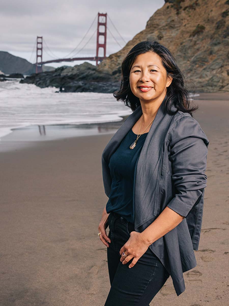 Perfumer and Nose Yosh Han on the beach in San Fransisco with the Golden Gate Bridge in the background